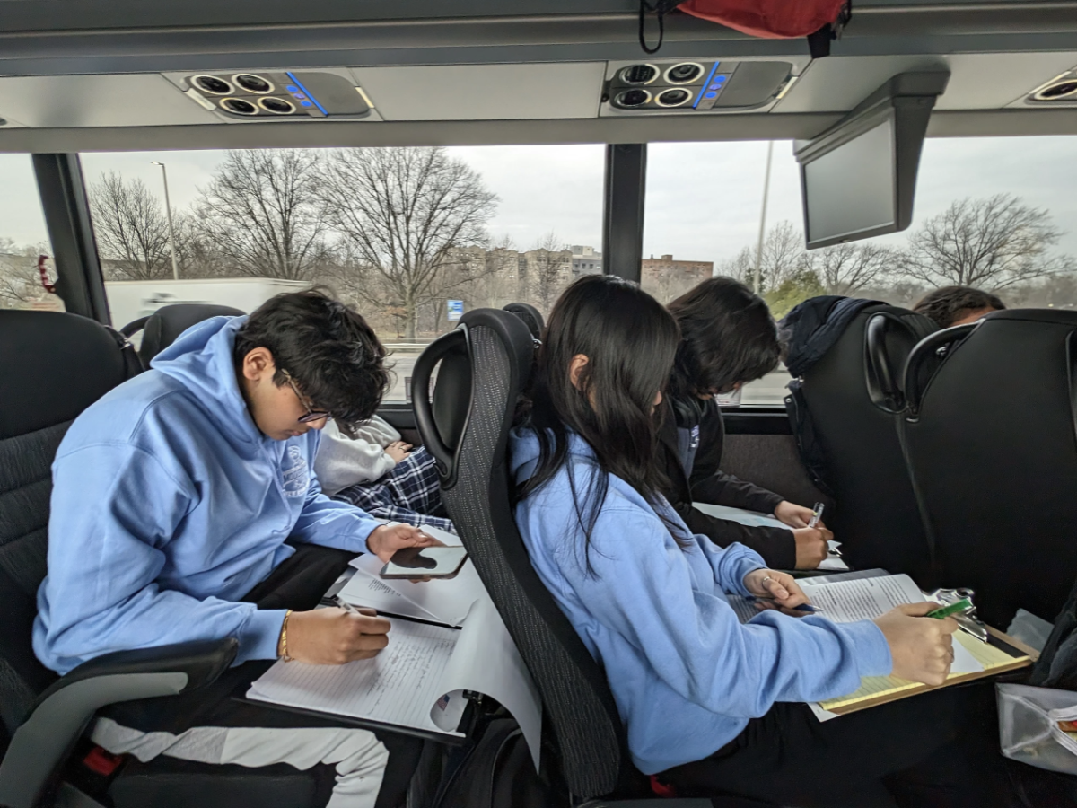 Sophomores Shohom Chakraborty and Sharon Xiao research during the bus ride to Boston.